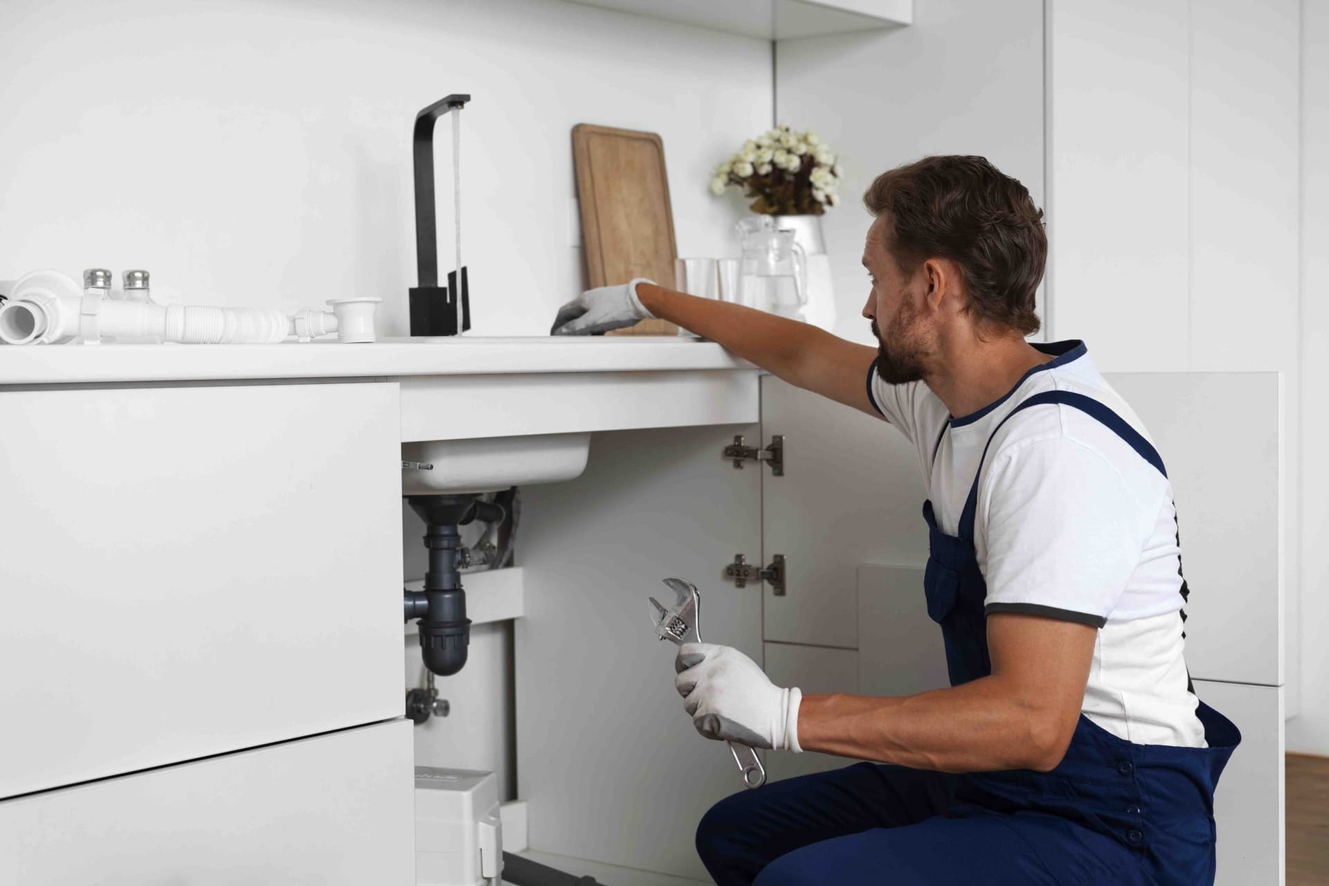 Licensed BR's plumber working under a Tillsonburg kitchen sink